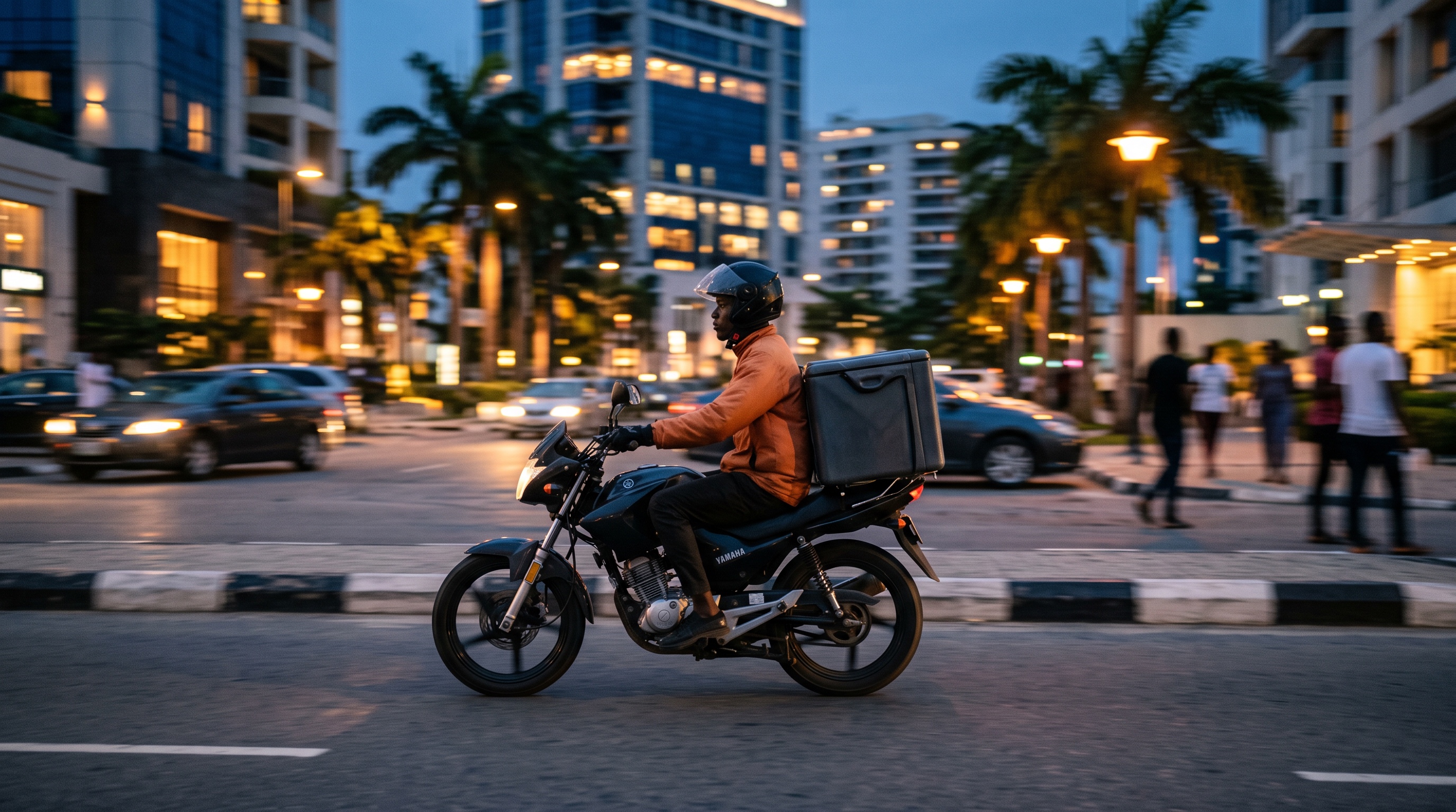 A delivery rider crossing an upmarket Lagos street at dusk